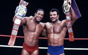 Teddy Atlas and Rocky Johnson show off their WWF tag team belts.