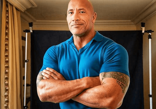 the rock dwayne johnson in a blue t shirt.